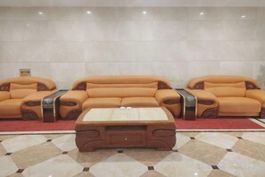 A seating area with three sofas and a coffee table. - Manzhouli Jinlongquan Hotel (Zhayanuoer Museum) (Hulunbuir)