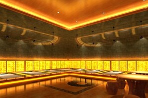 Eine großzügige Lobby mit einer zentralen Sitzgruppe, einer Wand mit Muster und einer Decke mit eingelassener Beleuchtung.