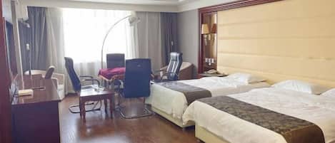 Una habitación de hotel con dos camas, un escritorio, una silla, una lámpara y un ventanal con cortinas.