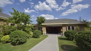 A residential house with a paved driveway, a front entrance, and well-maintained landscaping.