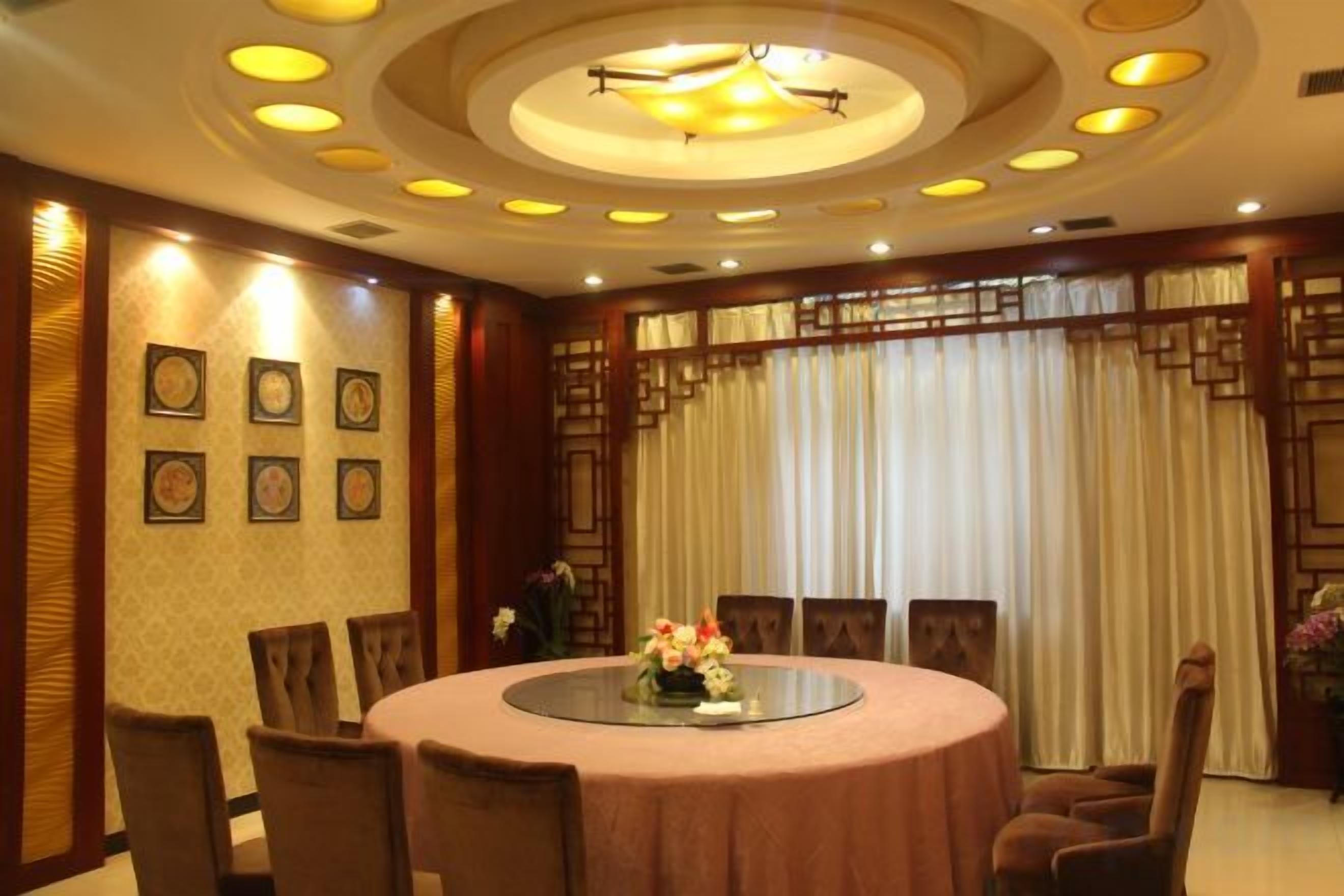 A conference room with a round table, chairs, and a chandelier.