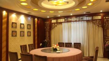 A conference room with a round table, chairs, and a chandelier.