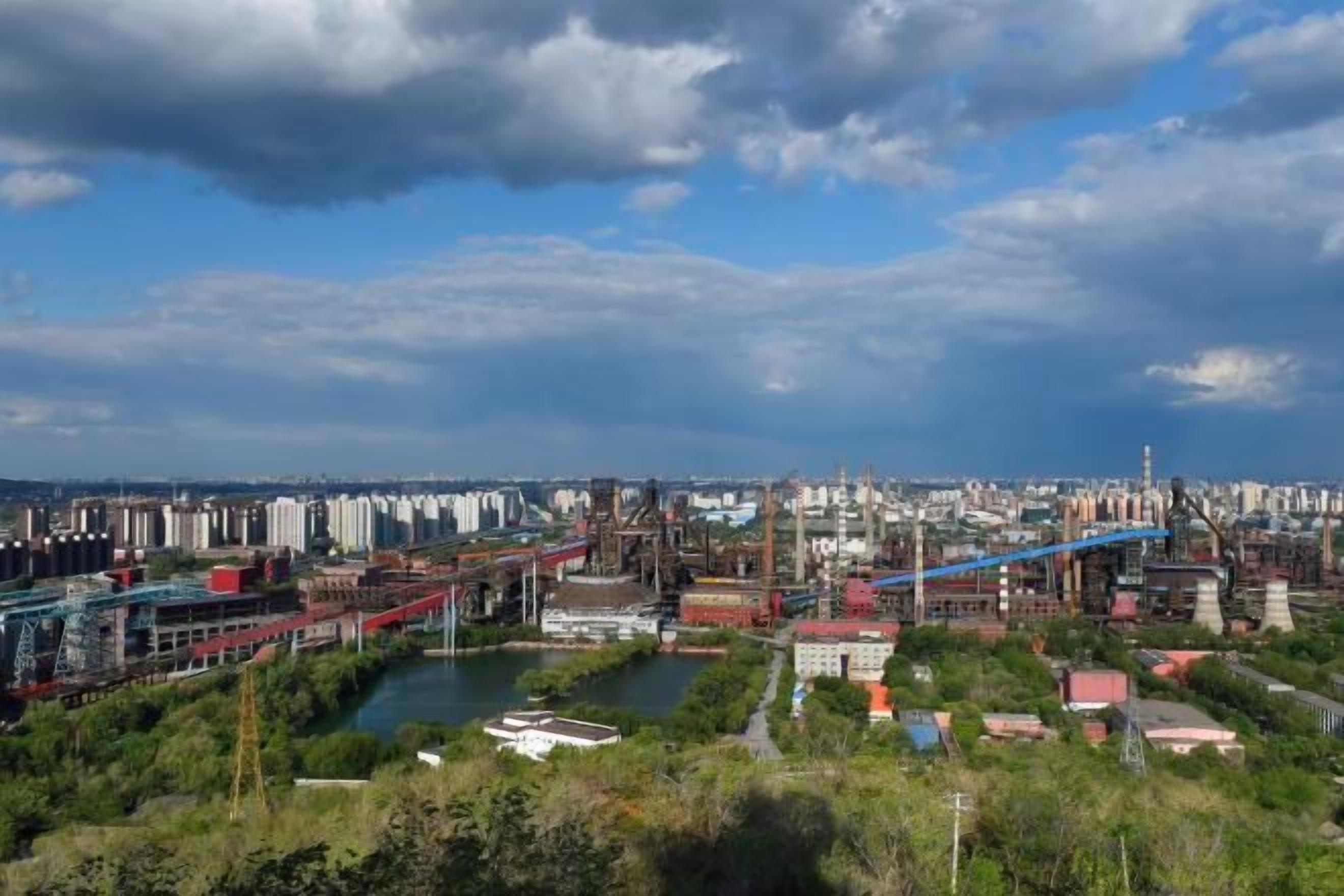 A cityscape with industrial buildings, a bridge, and a river.