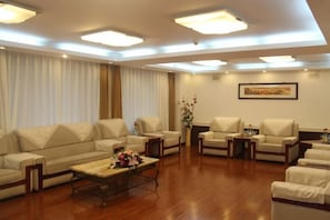 A spacious living room with a sofa set, a coffee table, and a painting on the wall.