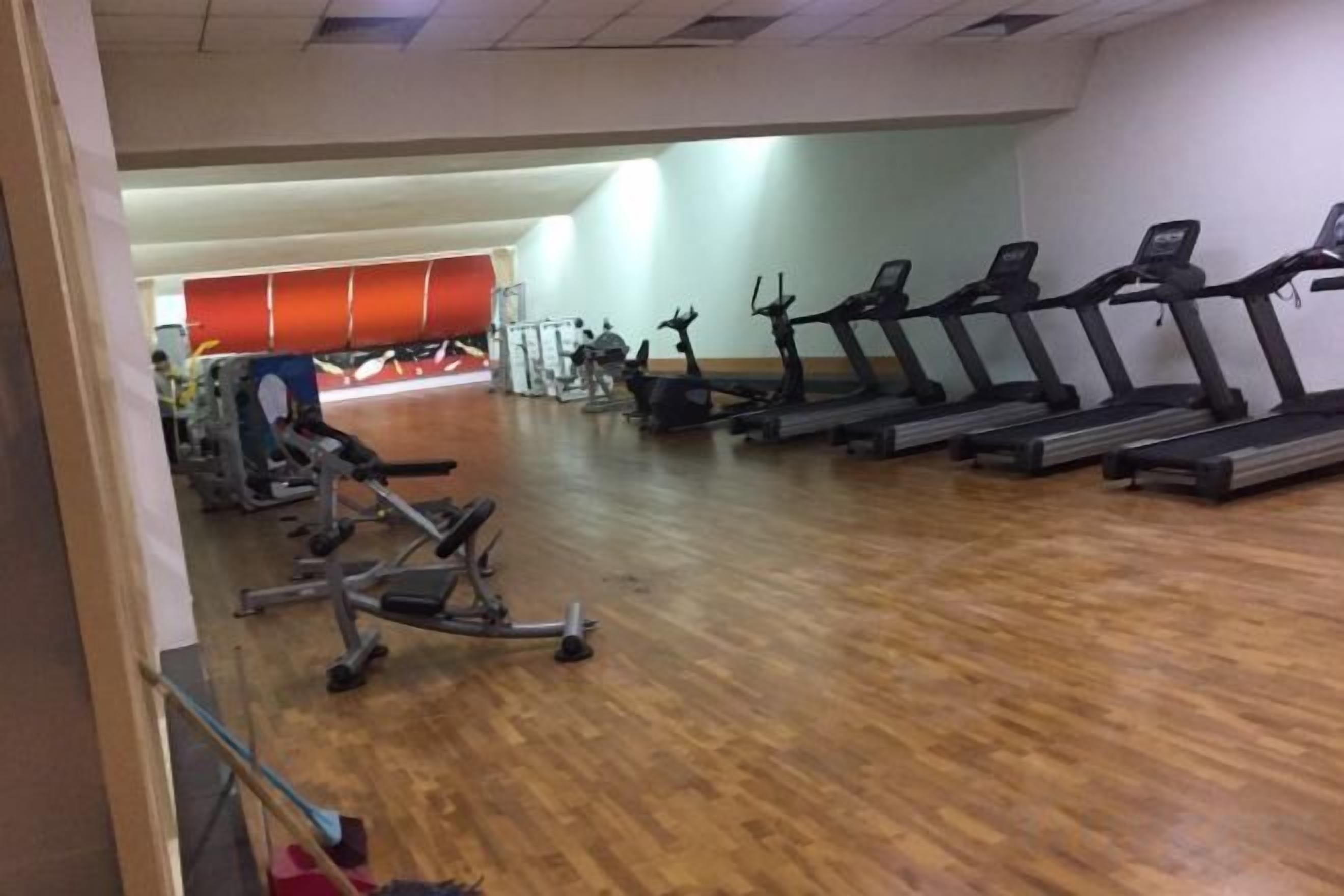 A gym with treadmills, stationary bikes, and weight machines.