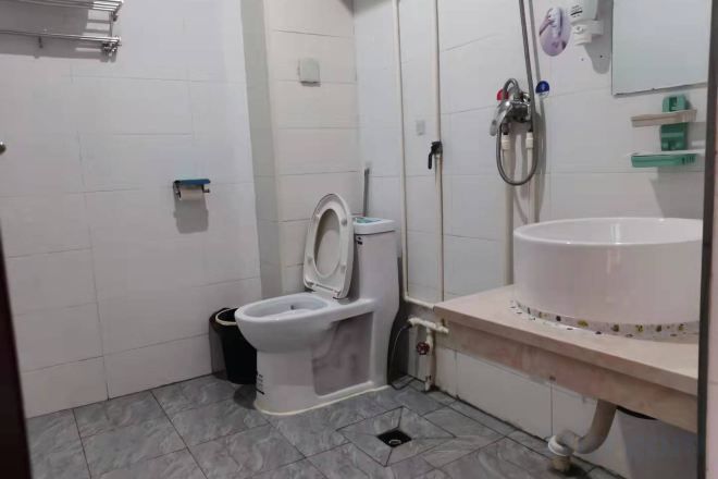 A bathroom with a toilet, sink, and shower.