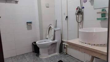 A bathroom with a toilet, sink, and shower.