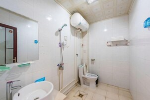Un baño con lavamanos, inodoro y ducha.