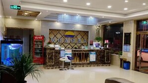 A hotel reception area with a reception desk, a fish tank, and a red vending machine. - jujia lianhe jiudian (Boye)