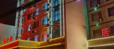A multi-story hotel with illuminated signage and a prominent entrance.