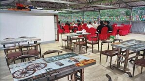 An indoor dining area with tables and chairs, a covered roof, and a view of the outdoors. - Xinglong Xiaoshan Farmhouse (Xinglong)