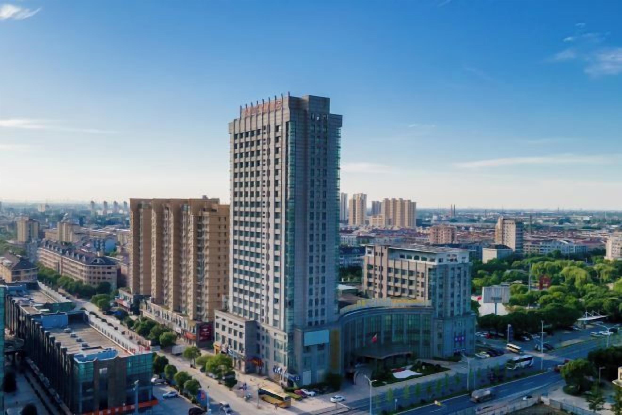 A high-rise building with multiple floors, surrounded by other buildings and a clear sky.