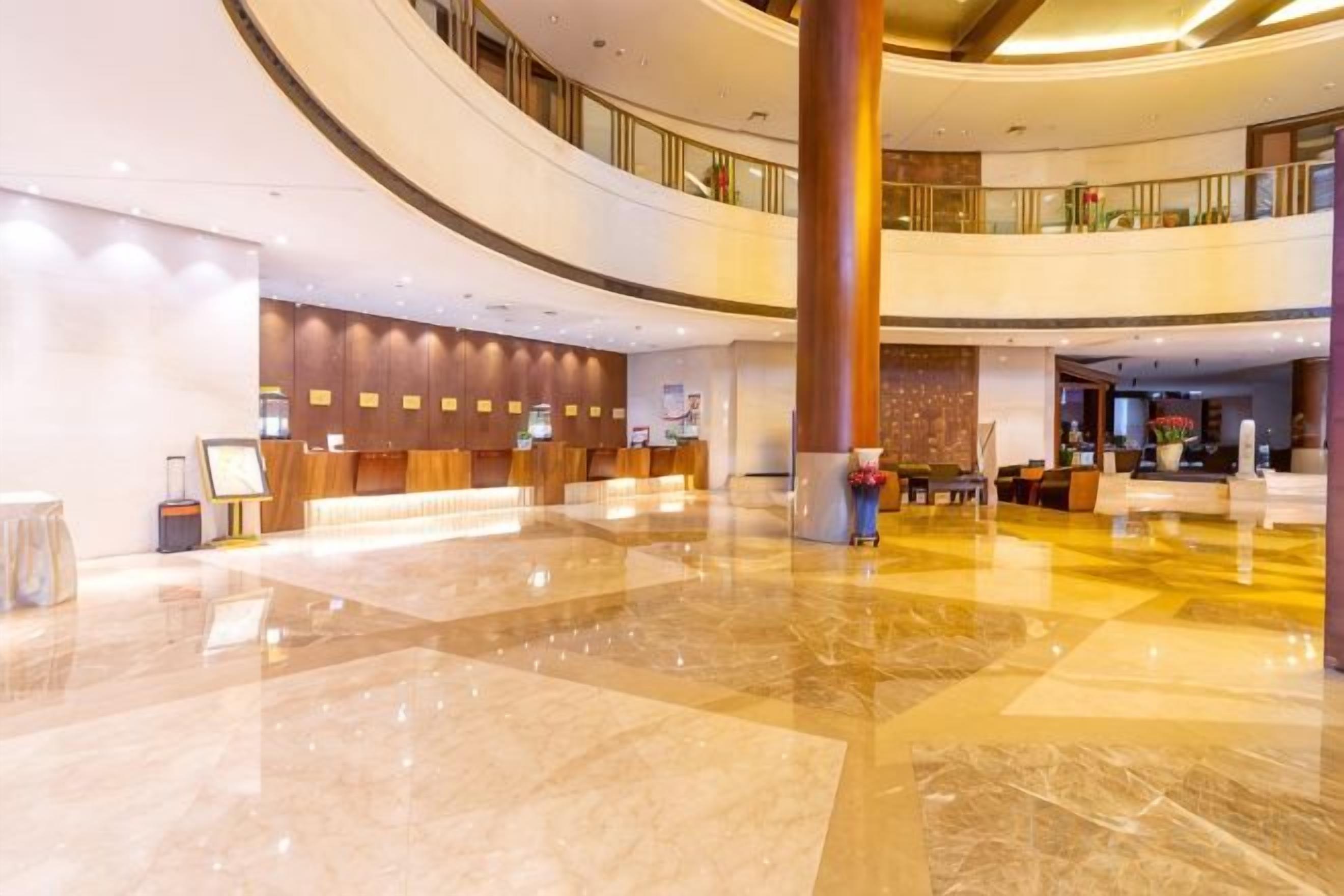 A spacious lobby with a reception desk, seating area, and a large pillar.