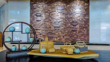 A display of ceramic items on a wooden platform with a brick wall backdrop.
