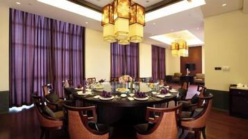 A conference room with a round table, chairs, and a chandelier.