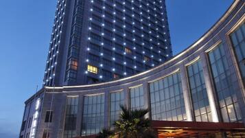 A high-rise hotel with a curved facade, large windows, and a modern design.