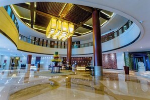 A spacious lobby with a high ceiling, a central chandelier, and a polished floor. - Rich Plaza Hotel (Tongxiang)