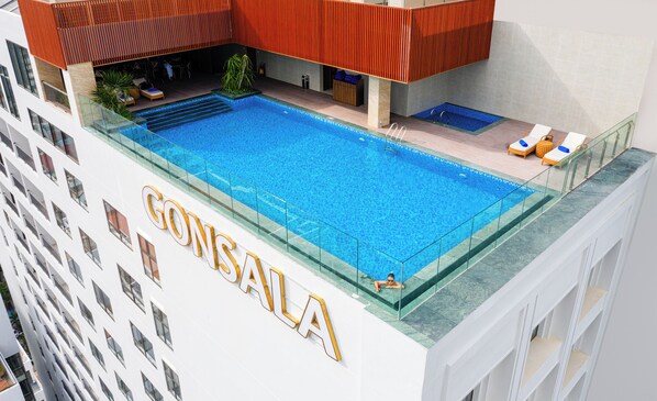 A hotel with a large swimming pool, a covered outdoor area with seating, and a visible name sign. - Gonsala Hotel Nha Trang (Nha Trang)