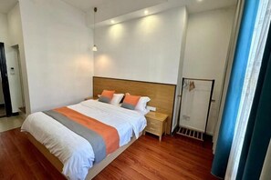 A modern hotel room with a large bed, bedside tables, a wardrobe, and a shower area. - Tianjiale Hotel (Yangshuo)