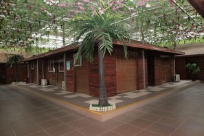 A building with a central palm tree, a covered walkway, and a tiled floor. - Xiaomaoshan Hotel (Nanning)