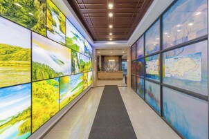 A hallway with large glass panels displaying various landscapes.