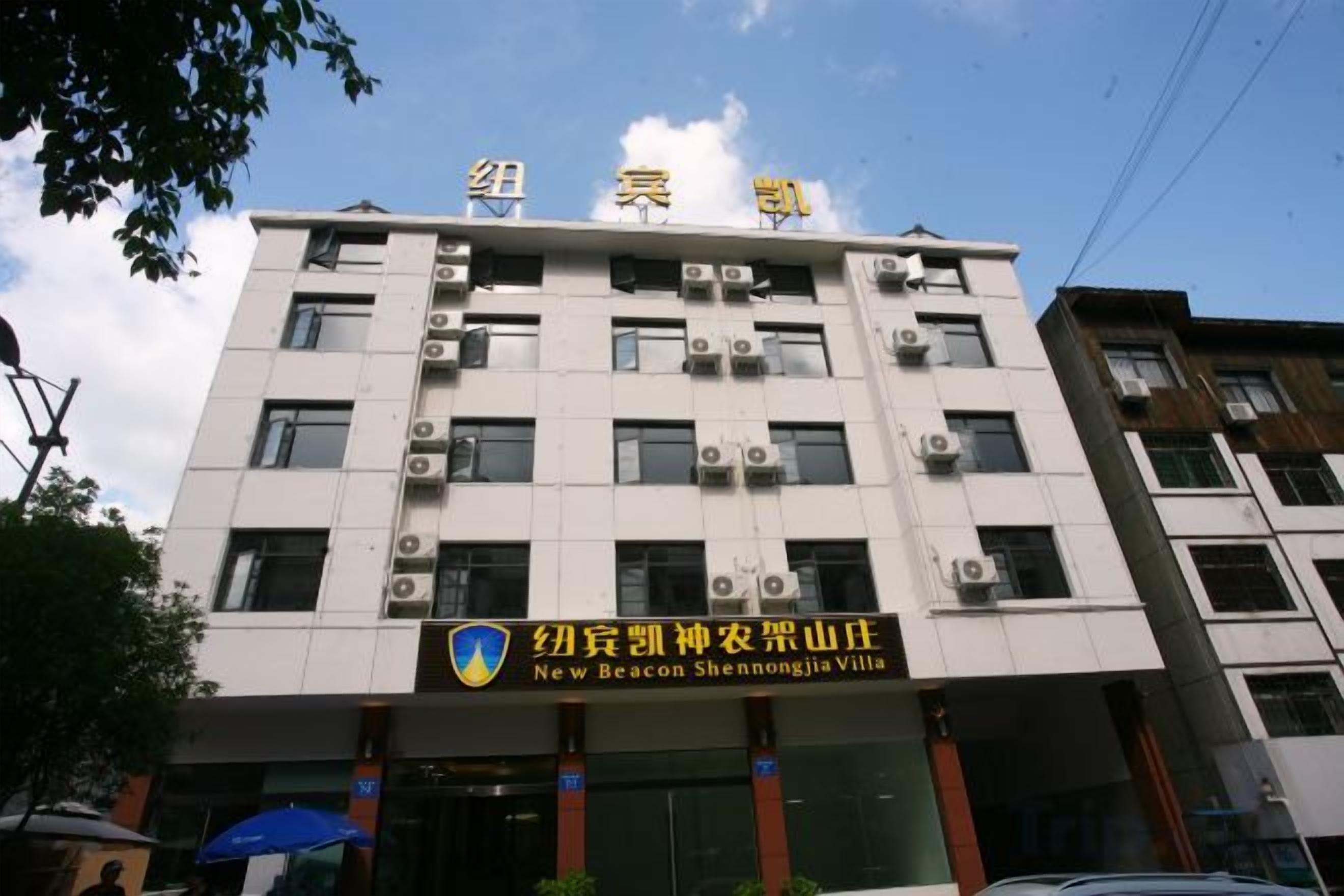 A multi-story building with a sign indicating 'New Beacon Shennongjia Villa'.