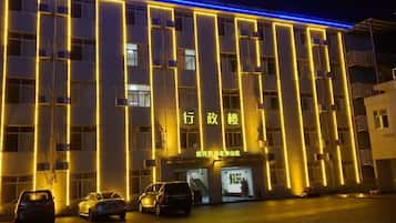A hotel with a modern facade, multiple floors, and a well-lit entrance.