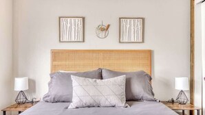 A neatly arranged bedroom with a large bed, two bedside tables, and a woven headboard. - Thunderhead Condo With Heated Pool & Mountain View (Government Camp)