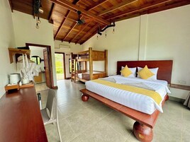 A spacious bedroom with a large bed, wooden headboard, and a dining area with a table and chairs.
