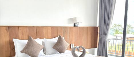 A hotel room with a bed, wooden headboard, and a view of the outdoors.