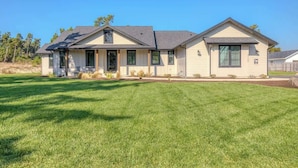 A two-story house with a front porch, a garage, and a well-maintained lawn.
