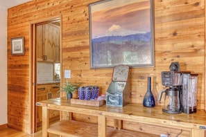 A wooden interior with a kitchen counter, a framed picture of a mountain, and a coffee maker. - Great Blue Lodge - Scenic escape | Hot tub & sauna (Government Camp)