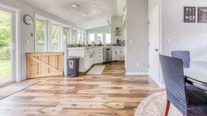 Una cocina amplia con suelo de madera, un ventanal y vistas al exterior.