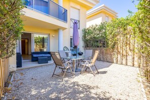 A two-story building with a balcony, a covered outdoor seating area, and a gravel patio.