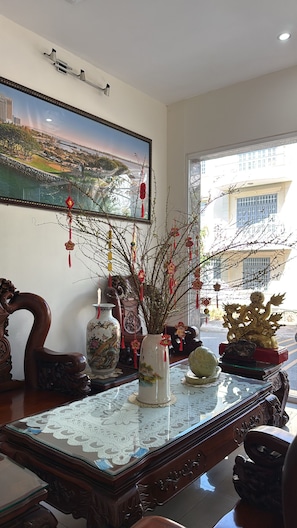 A traditional room with a large painting, a vase with branches, and various cultural decorations. - Thien Ha Hotel (Ho Chi Minh City)