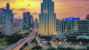 Eine Skyline mit modernen Hochhäusern, einer belebten Autobahn und einer Mischung aus Geschäfts- und Wohngebäuden.