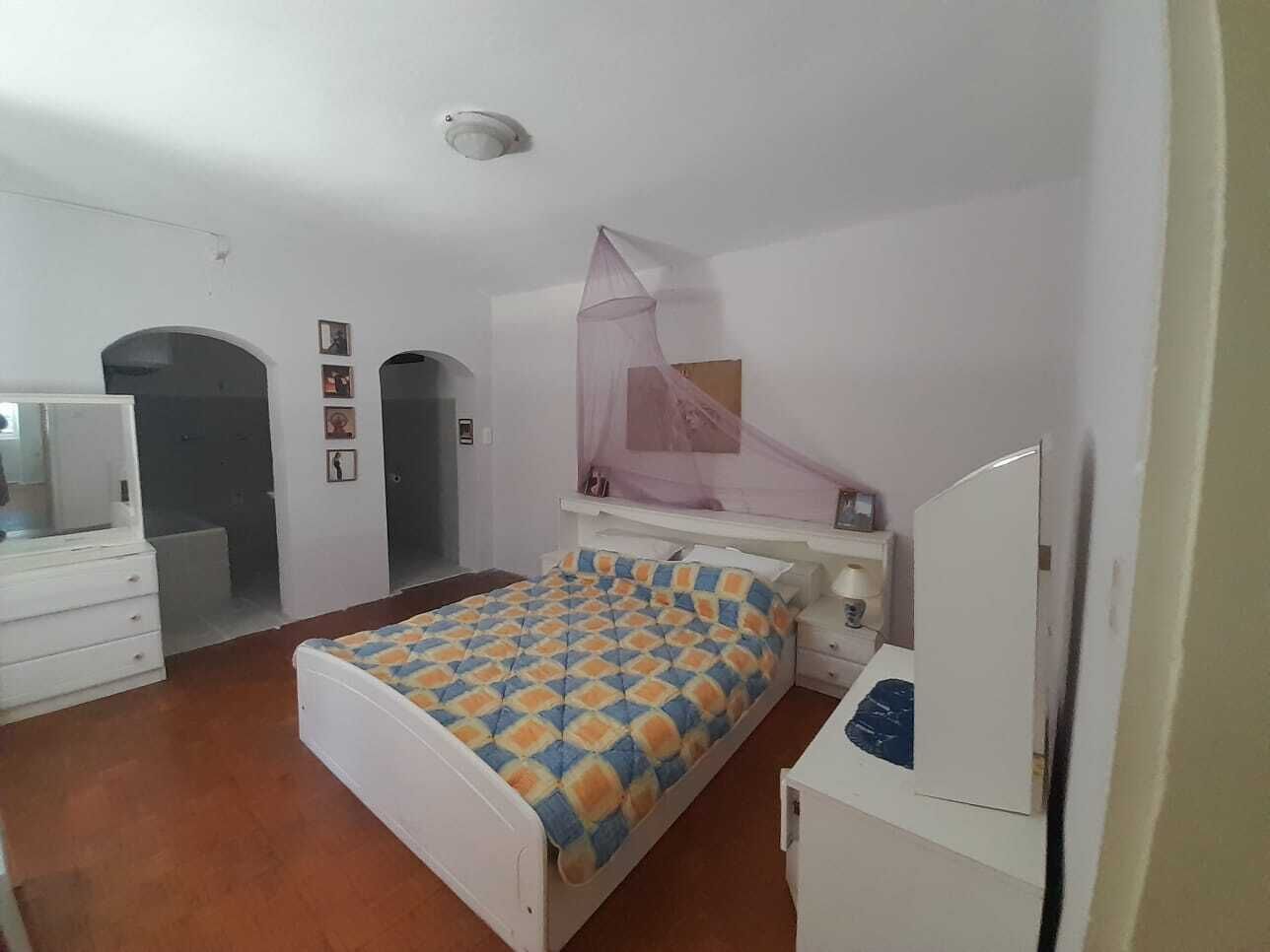 A bedroom with a bed, bedside tables, a wardrobe, and a mirror.