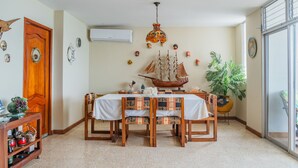 Comedor con mesa de madera, sillas y un modelo de barco como centro de mesa.