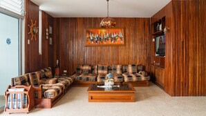 Una sala de estar con un sofá modular, una mesa de centro y paneles de madera.