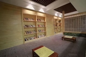 A room with bookshelves, a tatami mat floor, and a wooden table.
