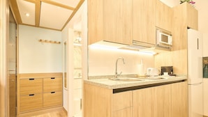 A modern kitchen with wooden cabinets, a granite countertop, a built-in microwave, and a stainless steel sink. - GuestReady - Bright and Cozy studio in Salamanca (Salamanca)