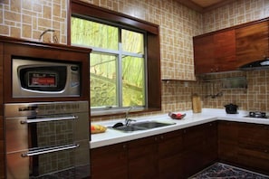 A kitchen with a built-in oven, a window, and a sink.