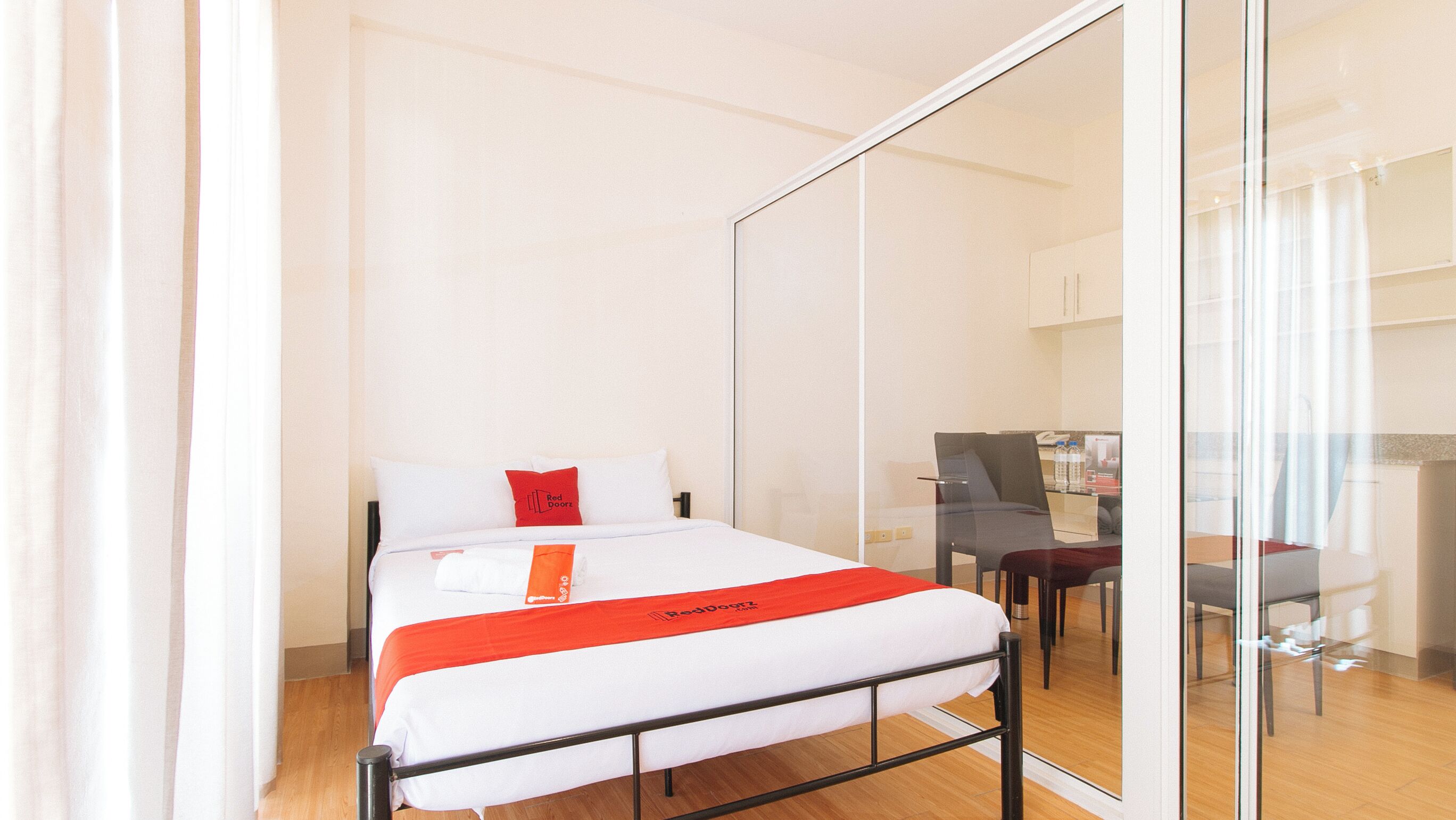A hotel room with a bed, a desk, and a chair.