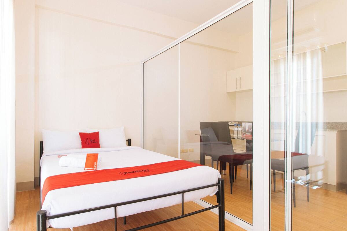 Una habitación de hotel con una cama, un escritorio y una silla.