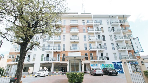 A multi-story residential building with balconies, a gated entrance, and a sign indicating a hotel. - Reddoorz Plus @ Alpina Heights Paranaque (Parañaque)