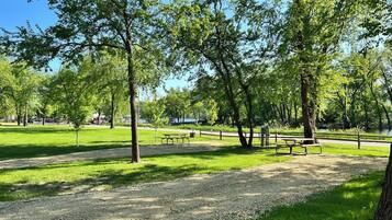 Ein Park mit Picknicktischen und einem Kiesweg.
