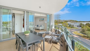 A modern balcony with a dining area, glass doors, and a view of the surrounding neighborhood. - Boasting coveted north facing views and an unrivalled coastal lifestyle. (Tweed)