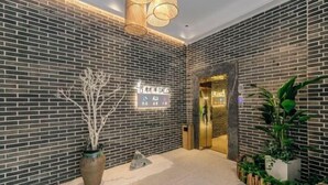 Un lobby moderno con pared de ladrillo, una mesa de recepción y una planta en maceta.