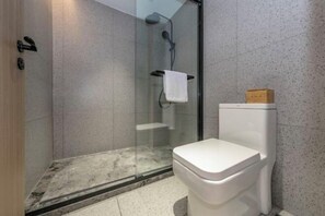 A bathroom with a glass-enclosed shower, a white toilet, and a towel rack. - xilinxiaoyuan Guesthouse (Longyan)