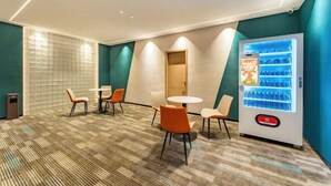 A hotel lobby with a vending machine, seating area, and a door. - Wind bell Hotel (Foshan Guicheng Metro Station) (Foshan)